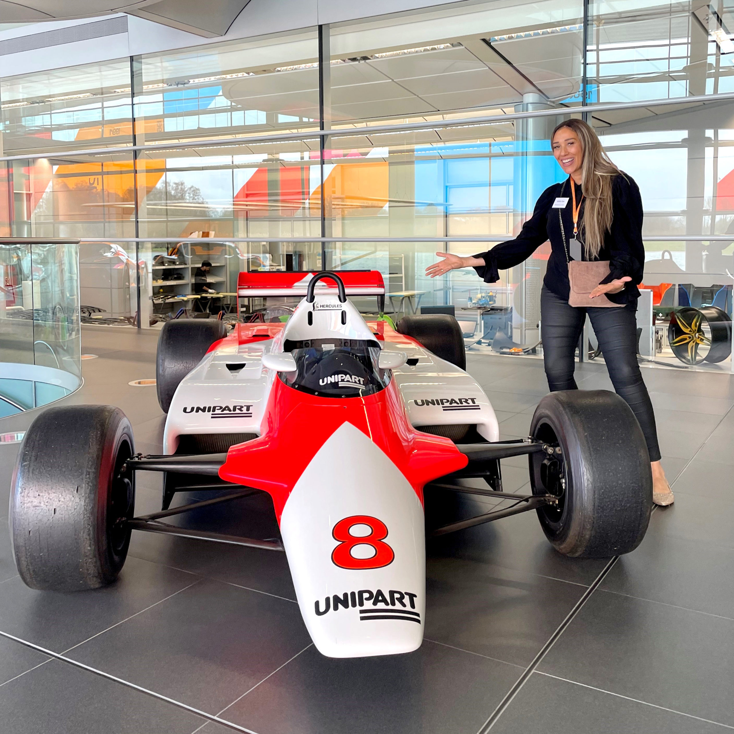 A woman posing beside a sleek racing car.