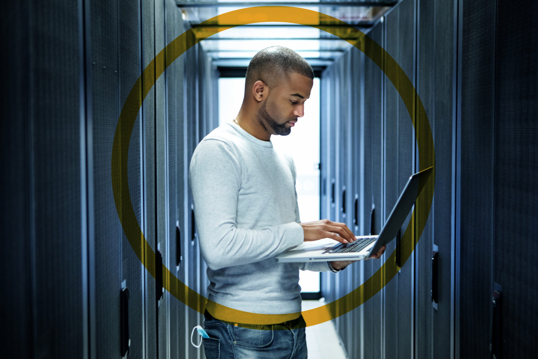 Man working on laptop in server room